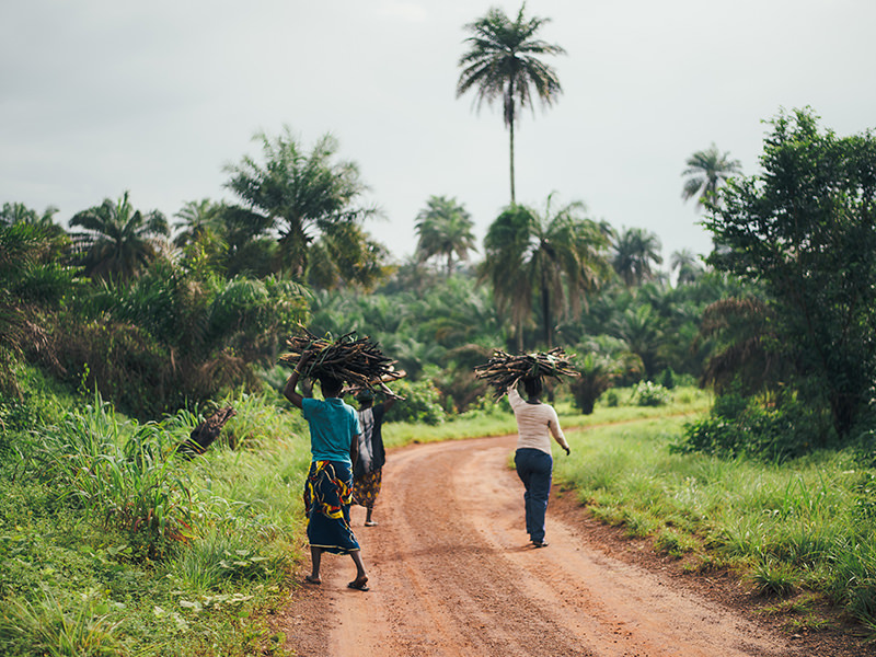 People carrying bundles along a rural road